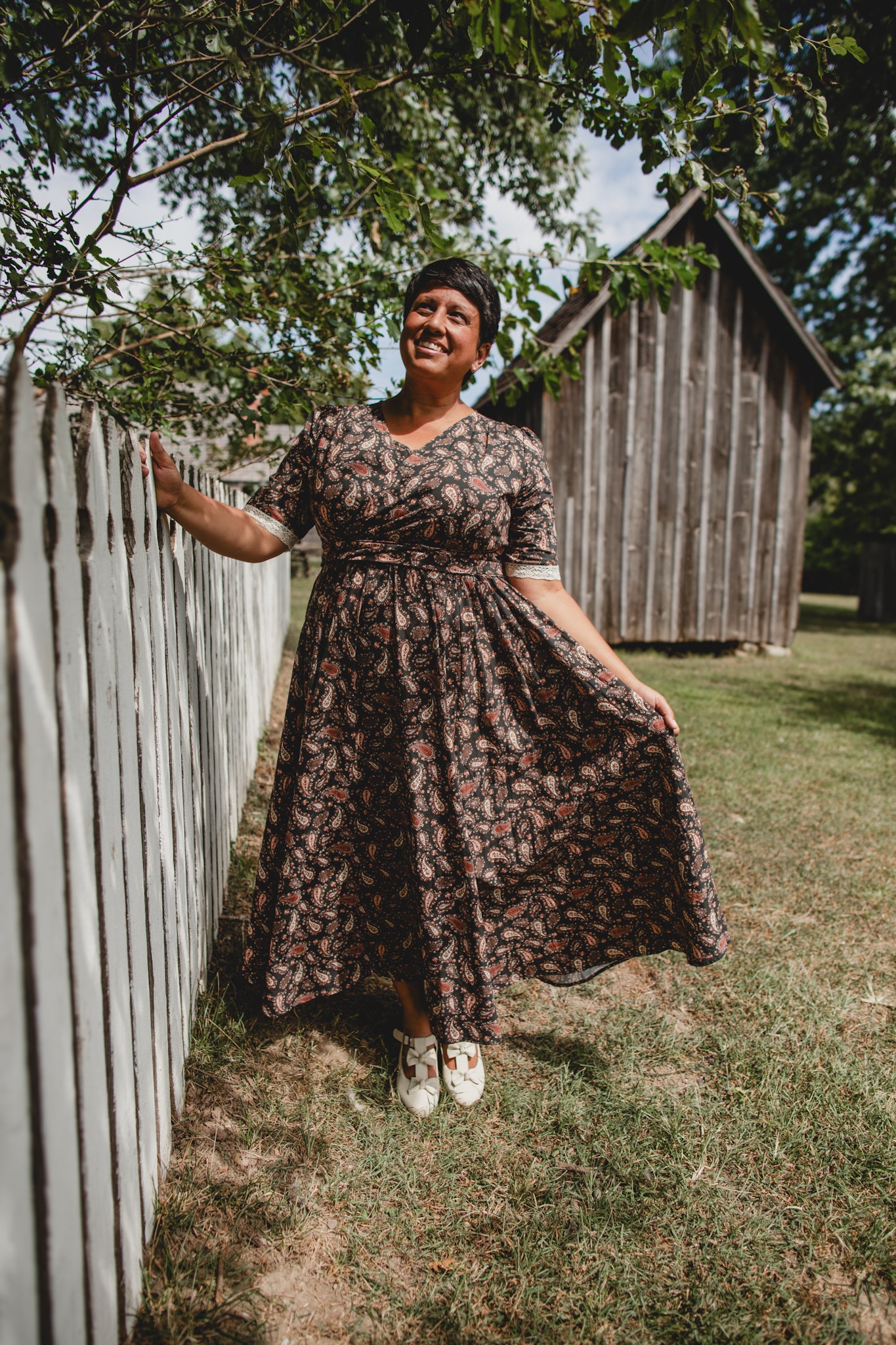 Woman in modest nursing dress by wooden fence