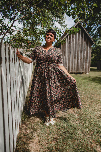 Woman in modest nursing dress by wooden fence