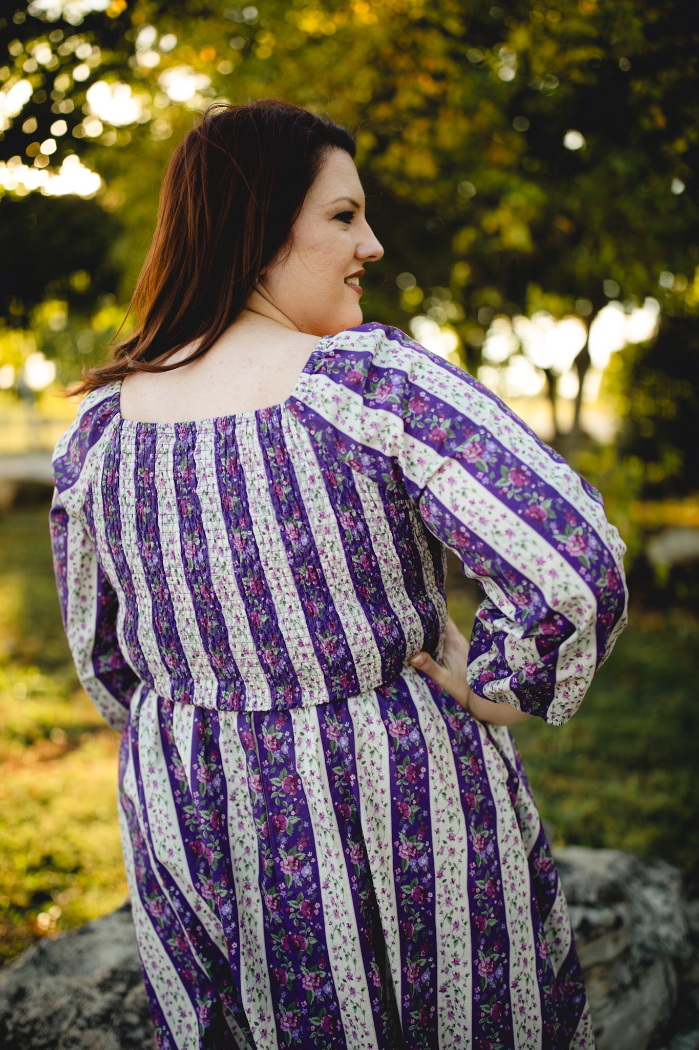 Modest nursing woman in purple striped dress outdoors