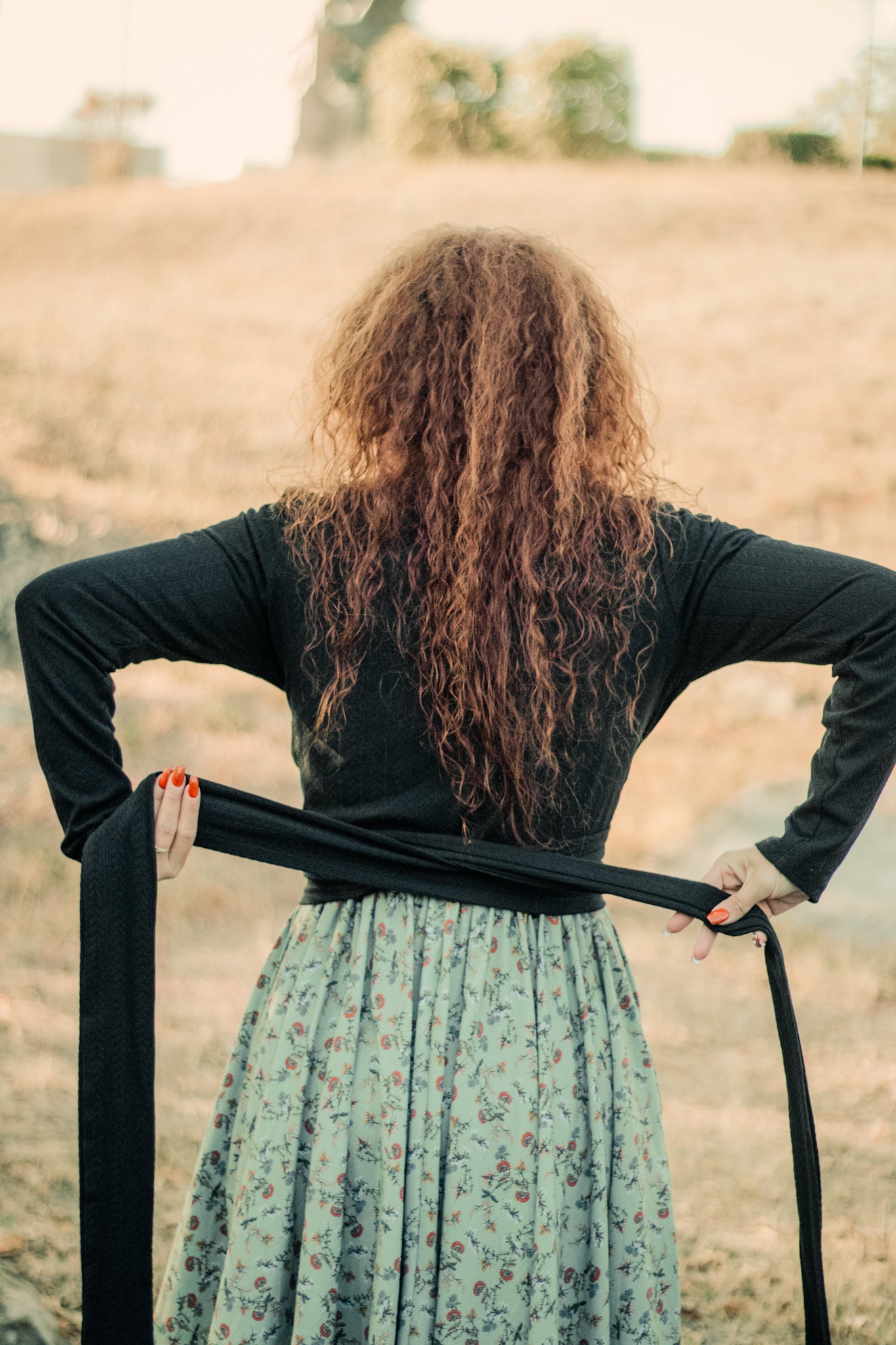 Woman in modest nursing-friendly black top and floral skirt outdoors