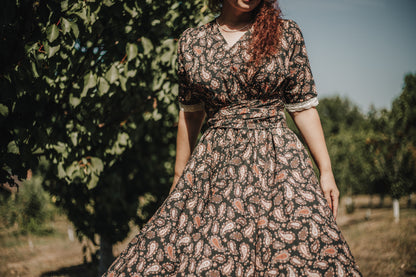 Woman in modest nursing dress standing in orchard