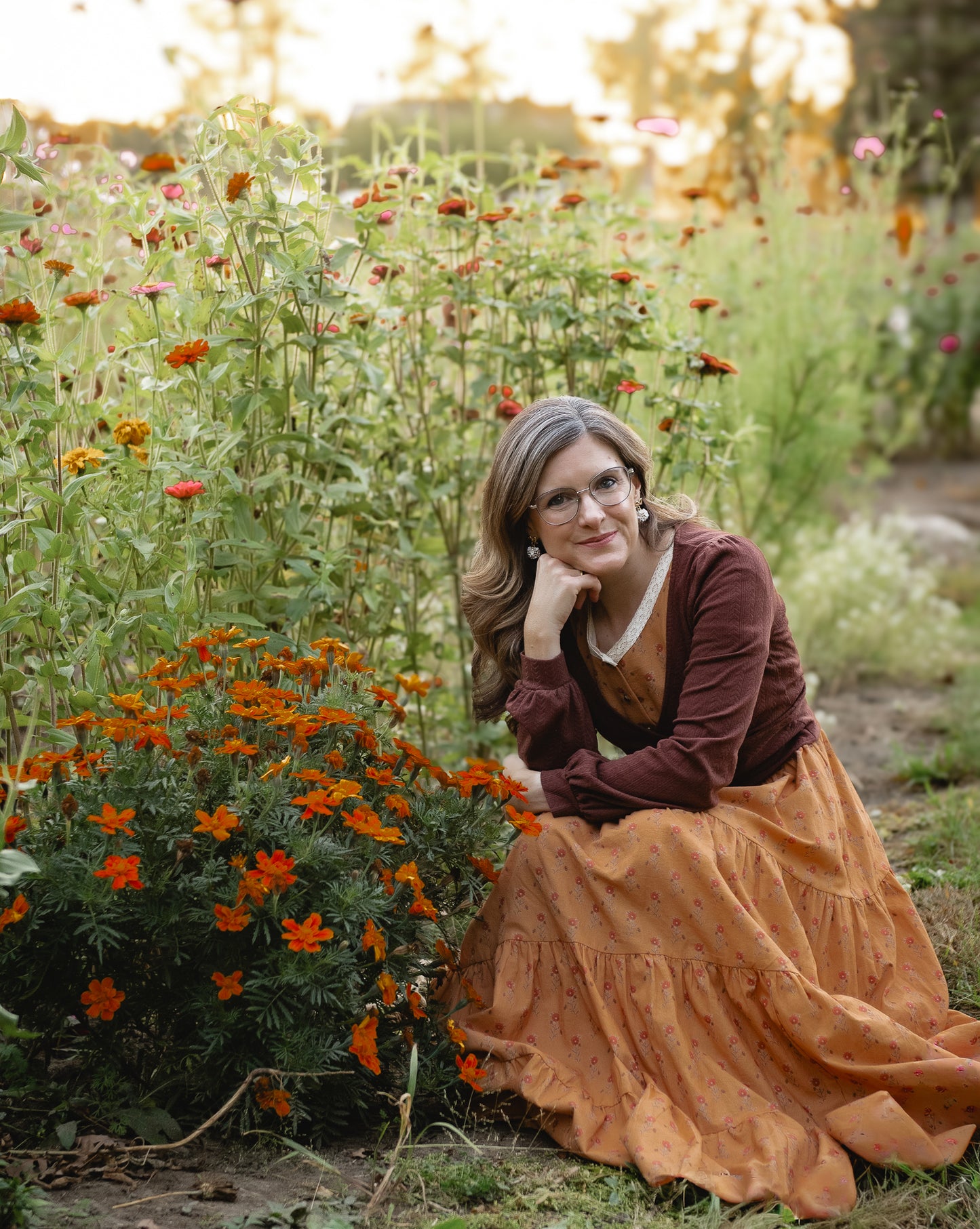 Woman in modest nursing dress sitting flower garden