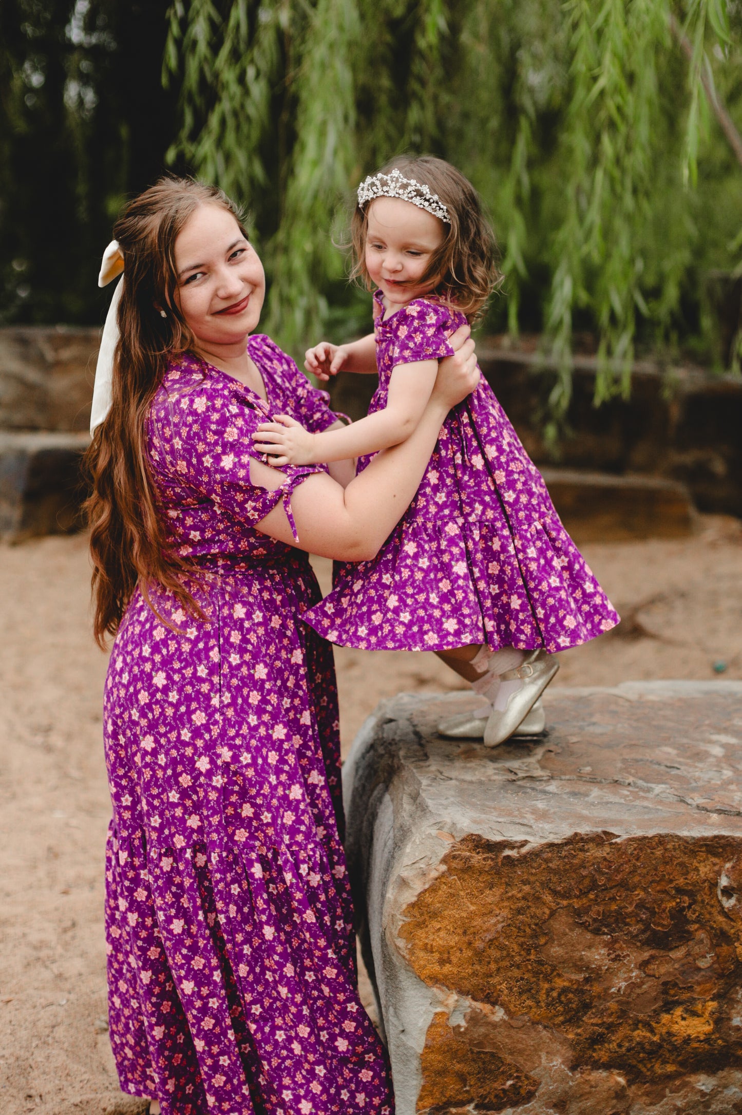 Mother in modest nursing floral dress with child outdoors