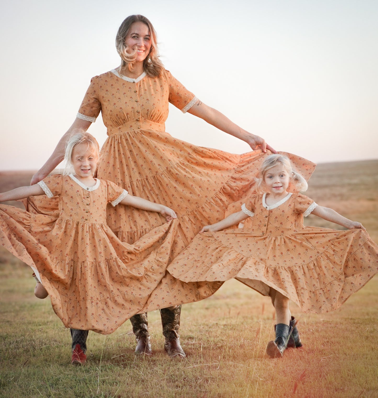Woman in modest nursing dress with two children in field