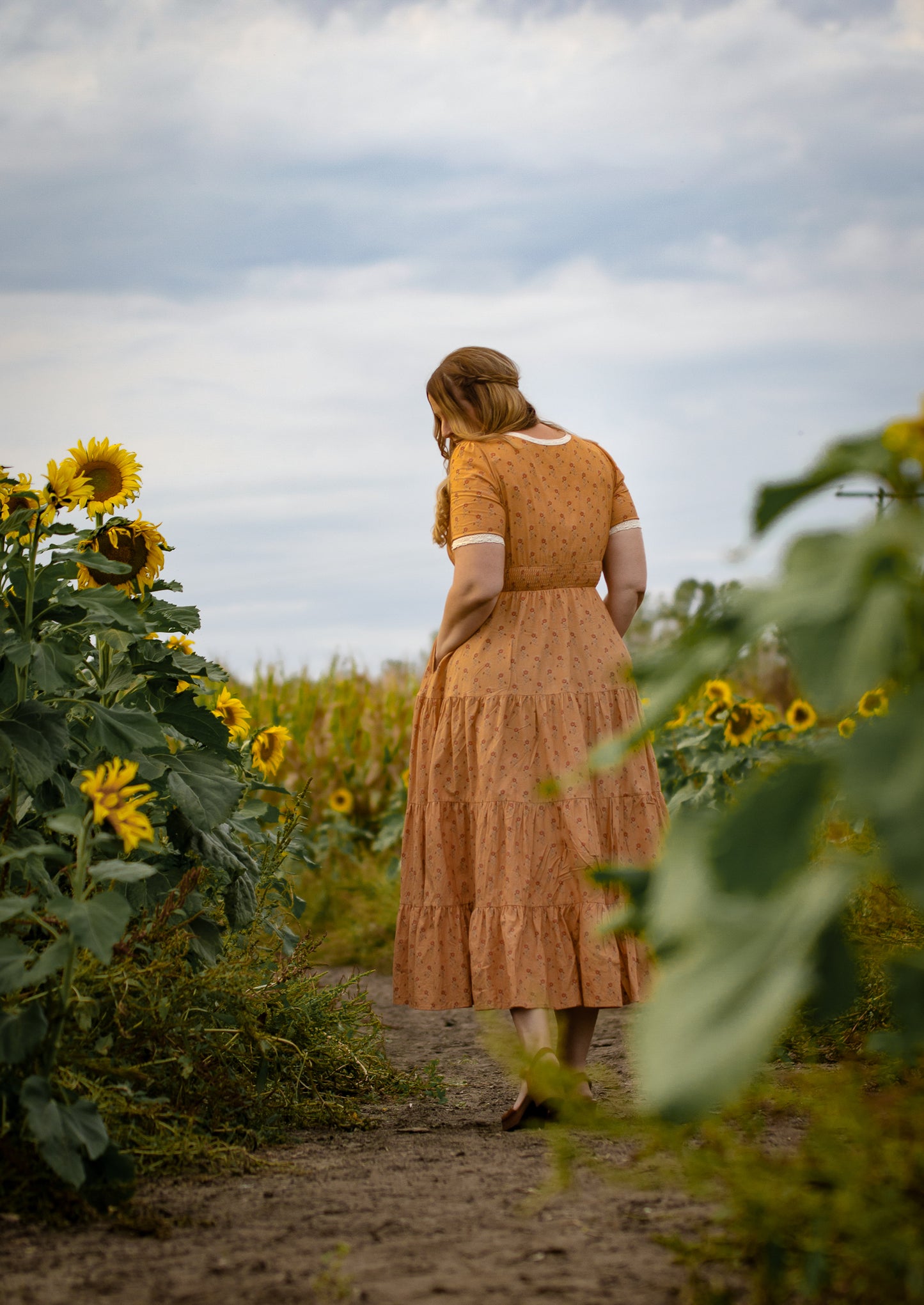 Woman in modest nursing dress sunflower field