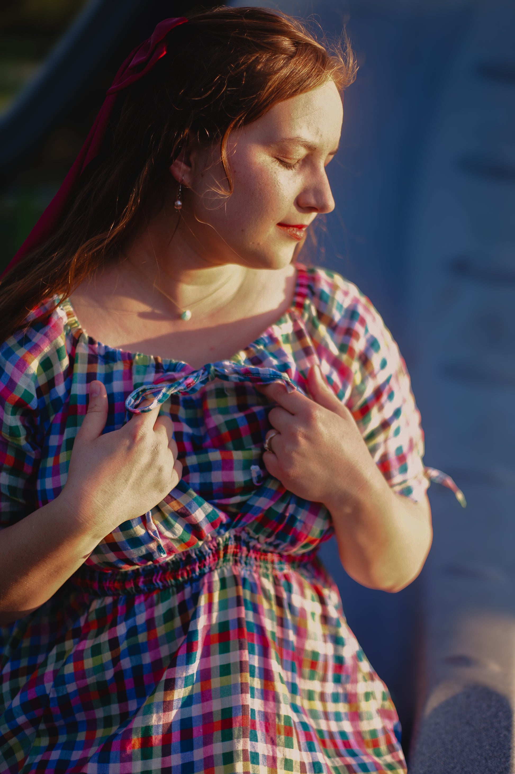 Woman wearing a colorful checkered modest nursing dress with a blurred background