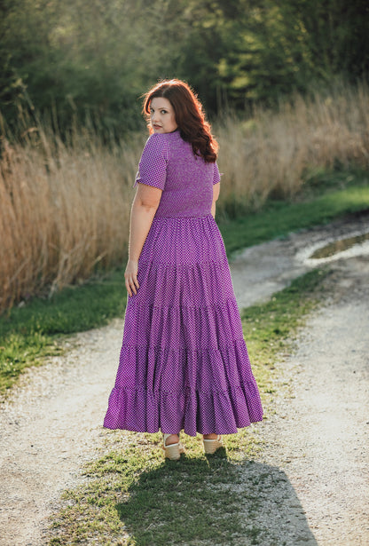A woman wearing a purple, gingham, five-tiered maxi modest nursing dress
