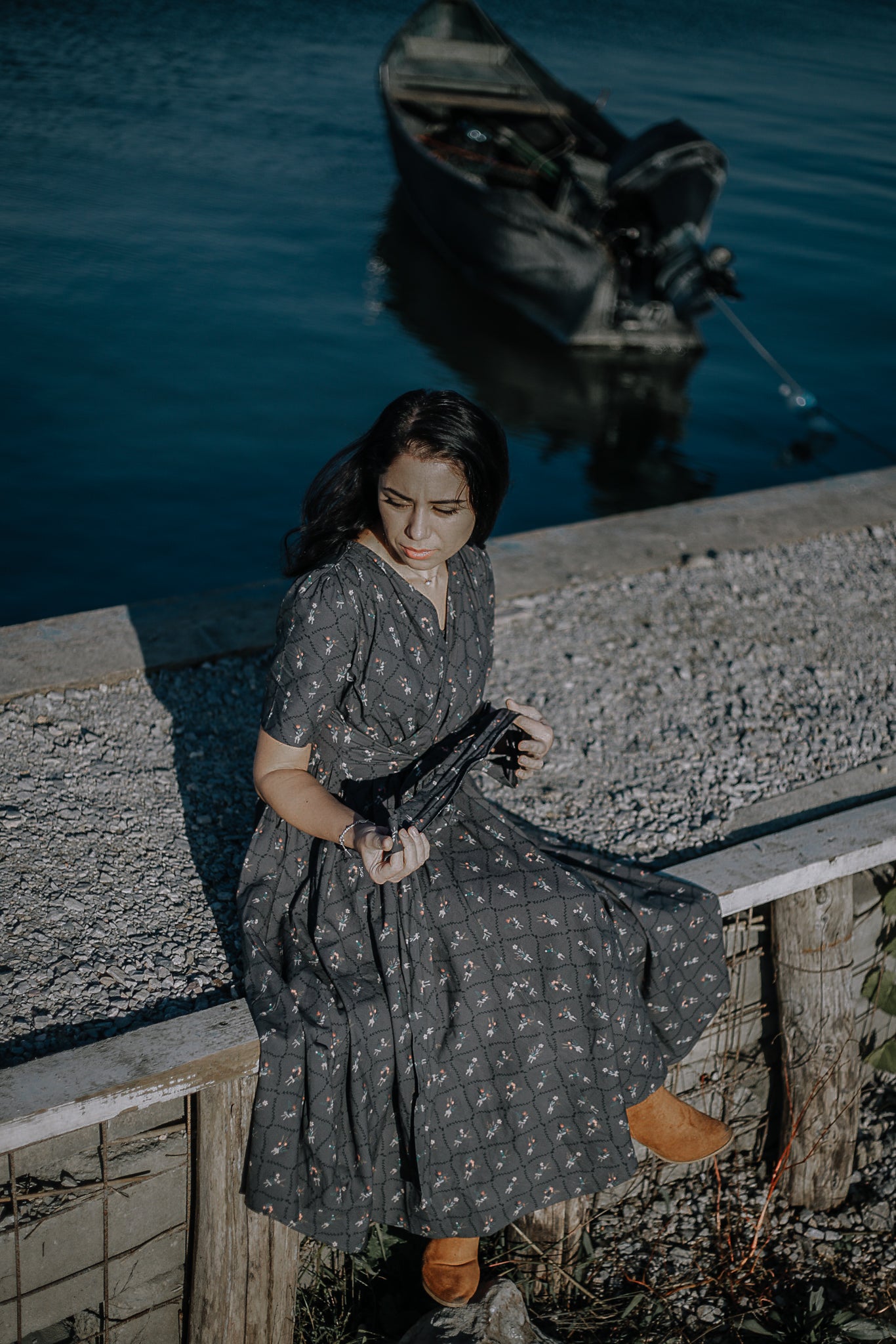 Modest nursing-friendly dark patterned dress by water