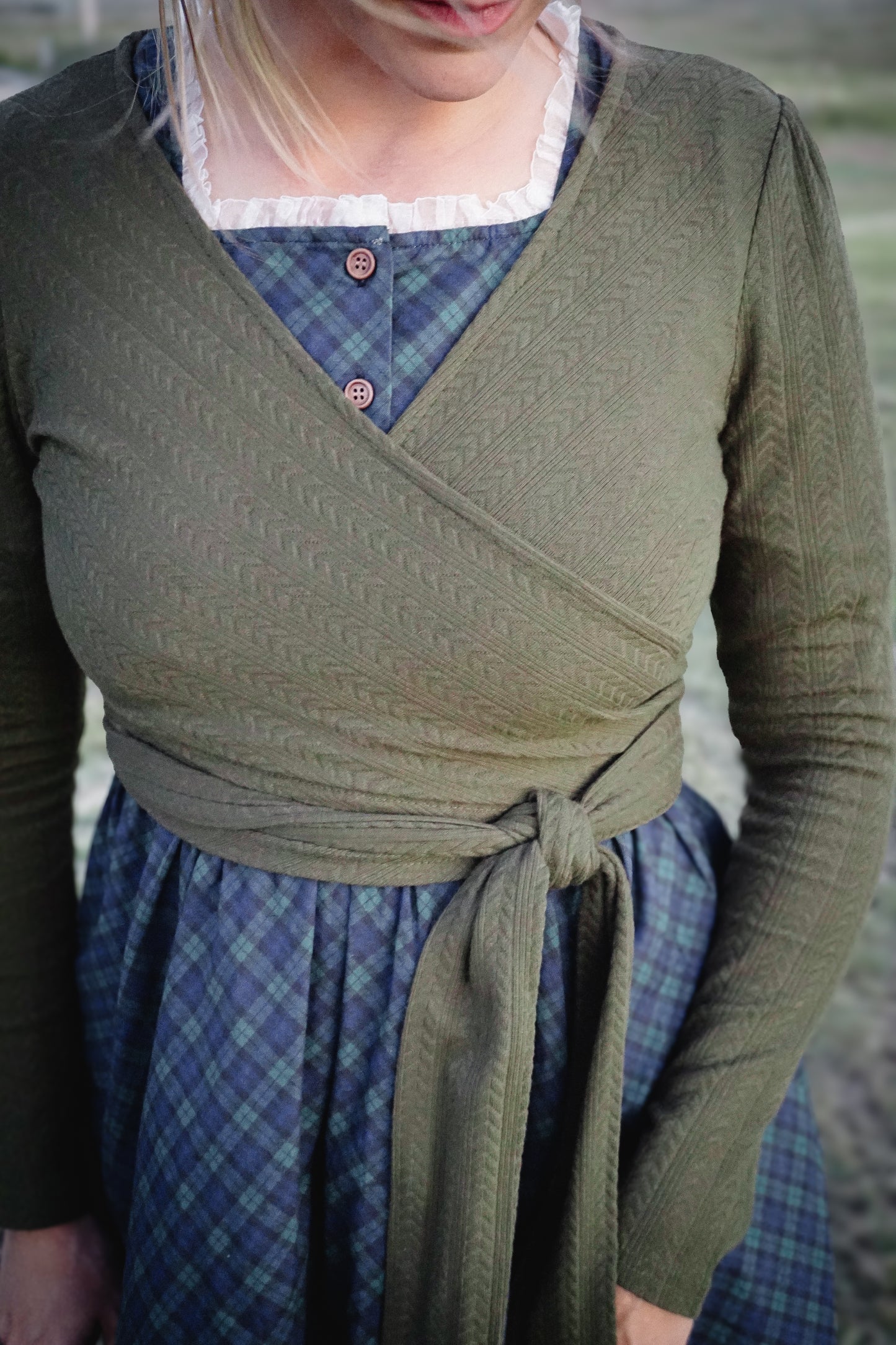 Woman in modest nursing wrap over plaid skirt