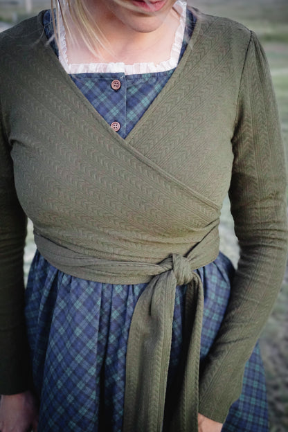 Woman in modest nursing wrap over plaid skirt
