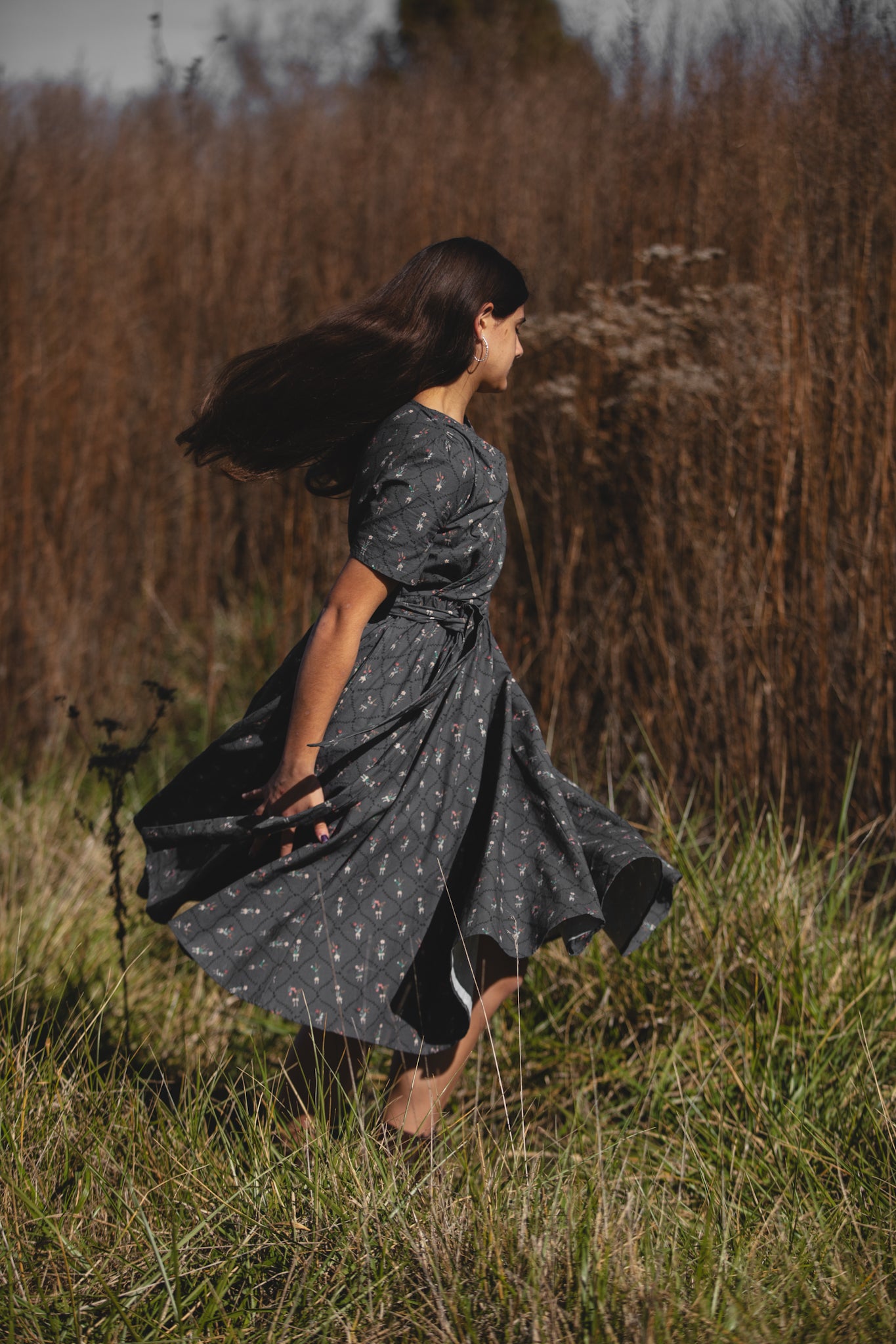 Modest nursing-friendly dark dress in tall grass