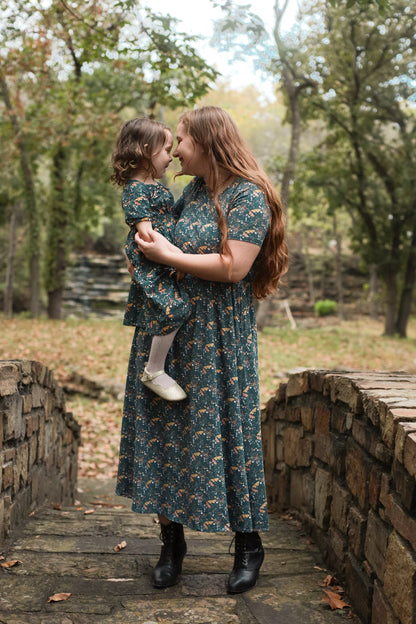 Woman in modest nursing dress with child on bridge