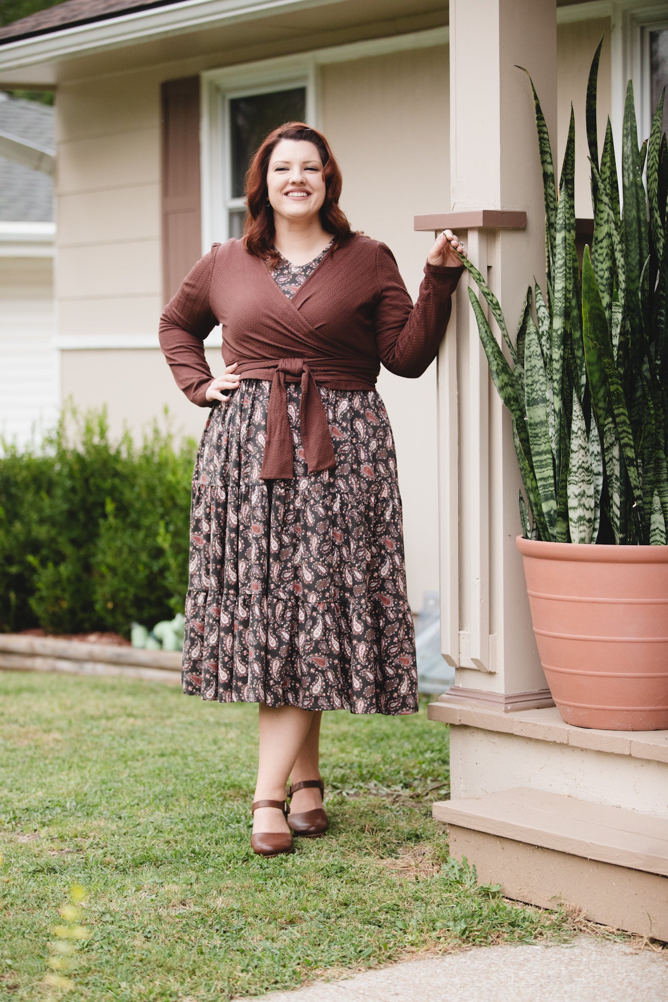 Woman in modest nursing outfit outdoors near house