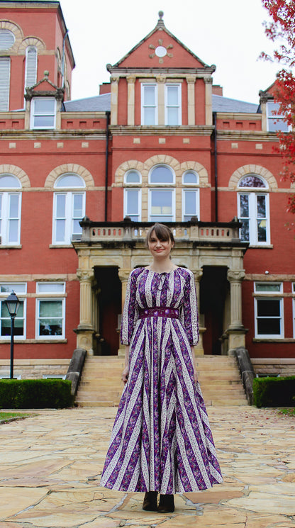 Modest nursing woman in purple dress at red brick building