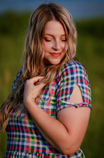 Woman wearing a colorful plaid modest nursing dress in a natural setting