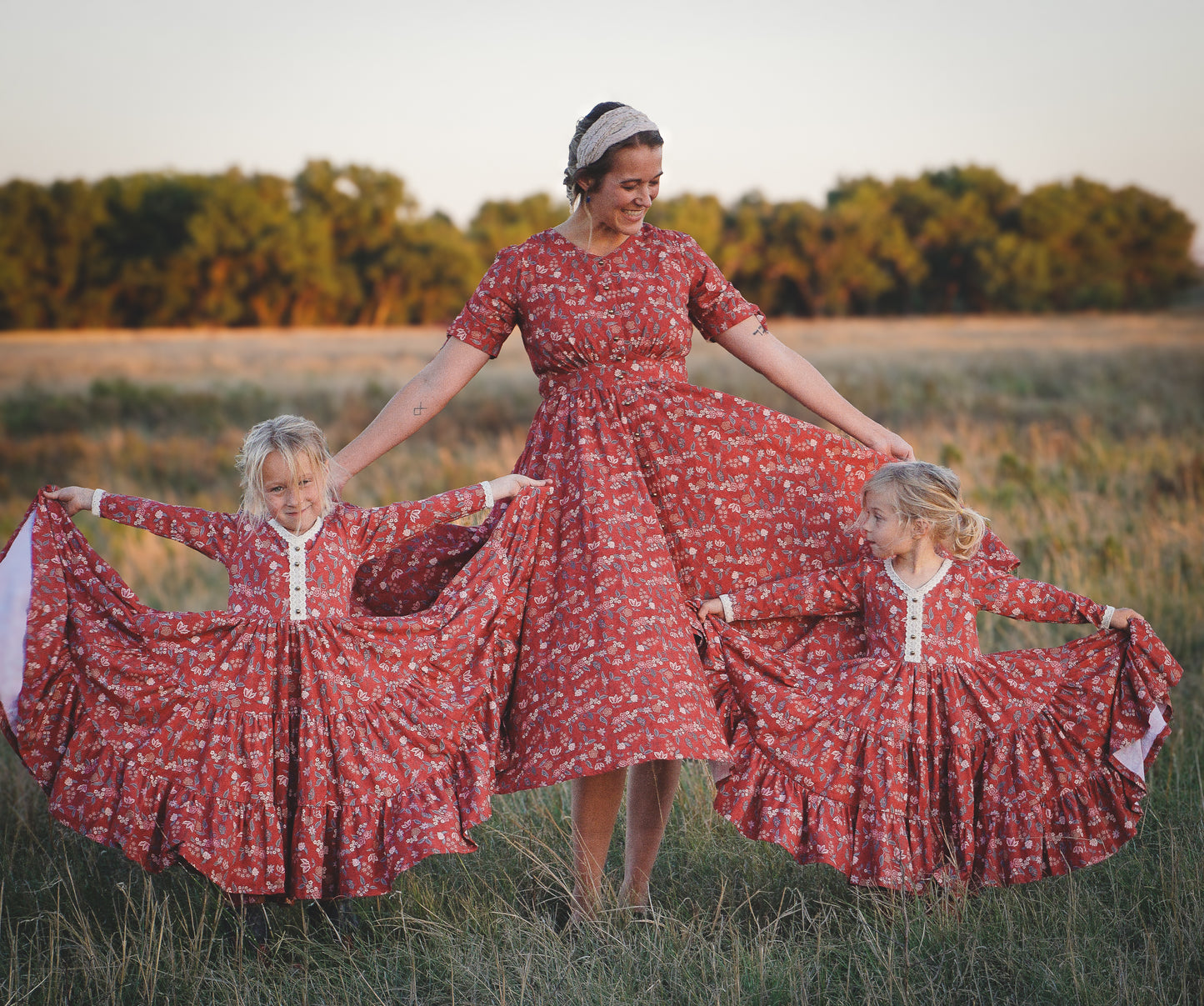 Modest nursing woman with two children in matching red floral dresses
