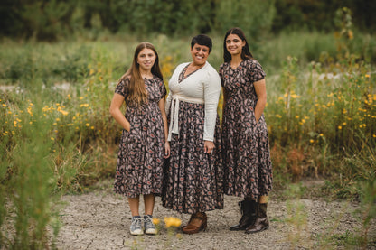 Three women in modest nursing dresses in wildflower field