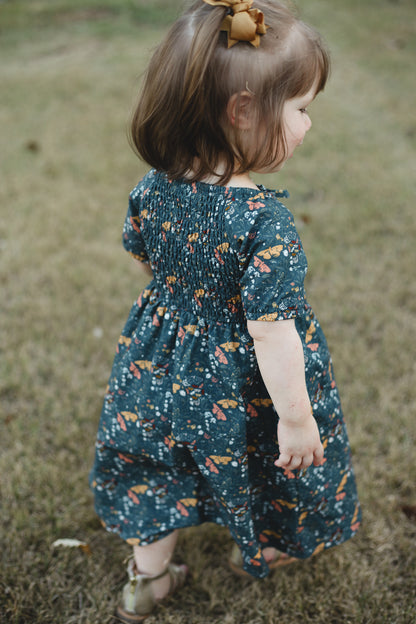 Child in modest floral dress outdoors