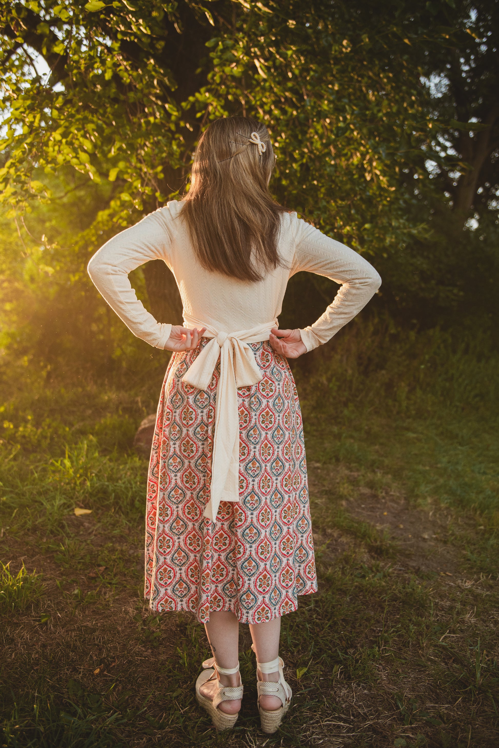 Woman in modest nursing dress in sunlit forest