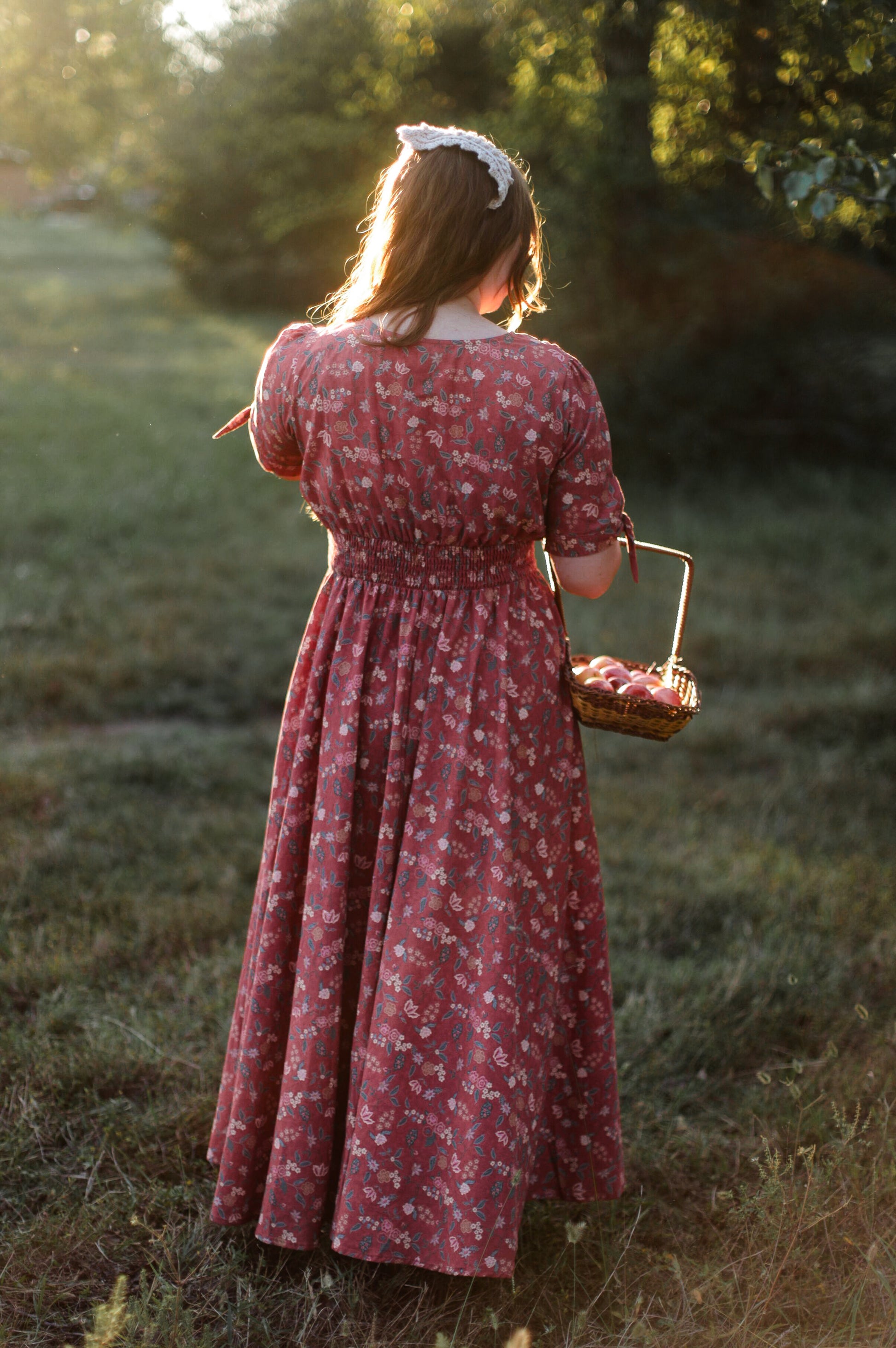 Woman in modest nursing dress with basket in field