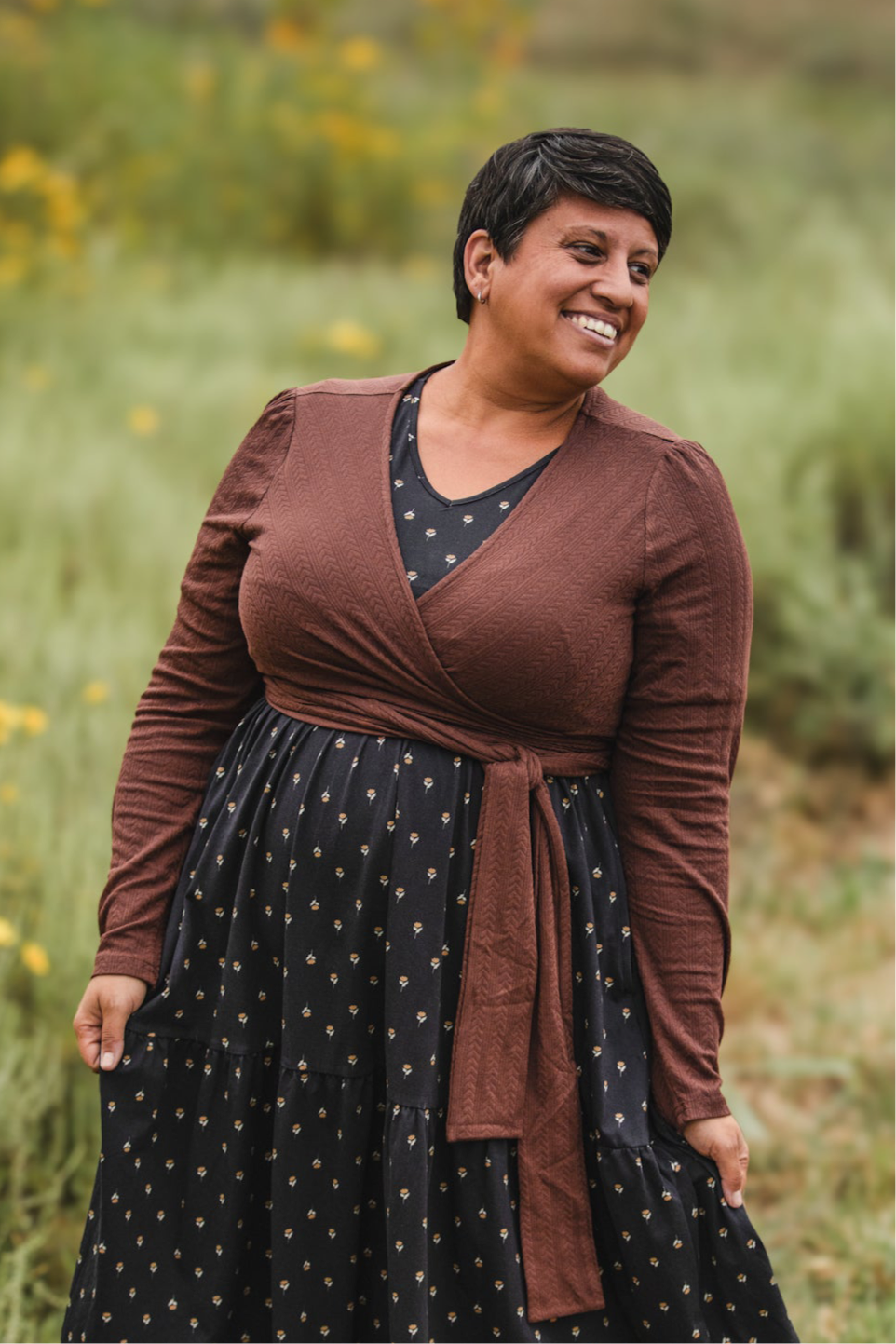 Woman in modest nursing wrap over patterned dress