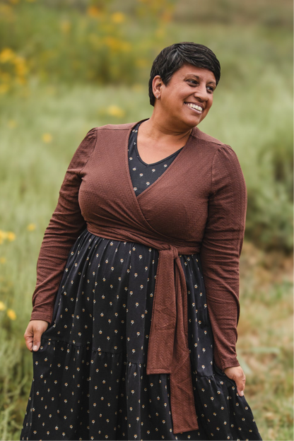 Woman in modest nursing wrap over patterned dress