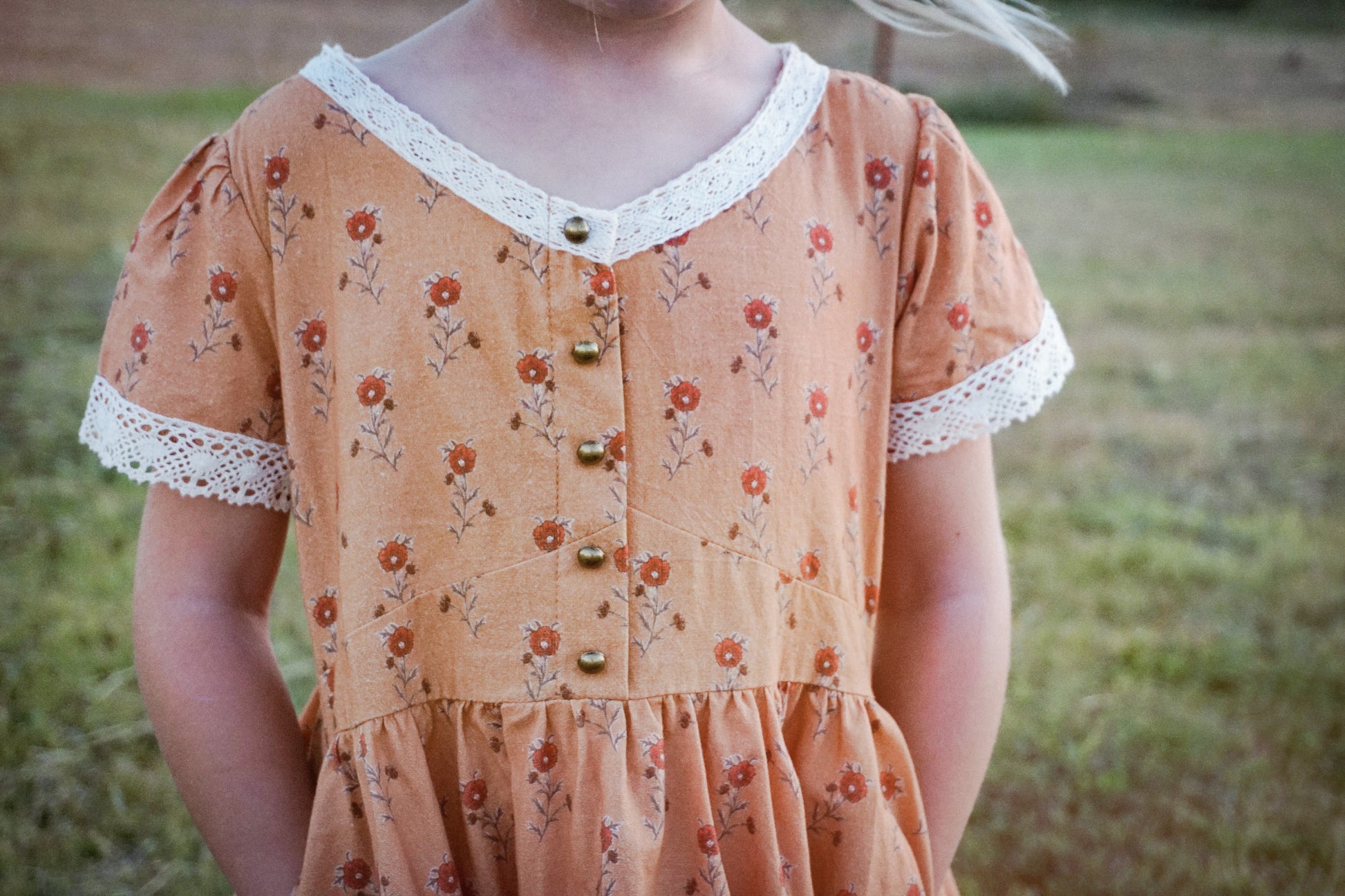 Child in modest floral dress outdoors