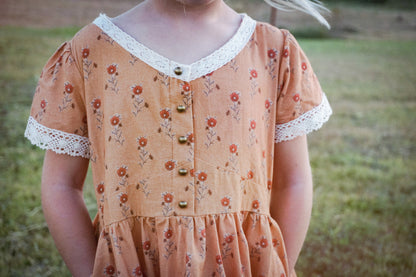 Child in modest floral dress outdoors