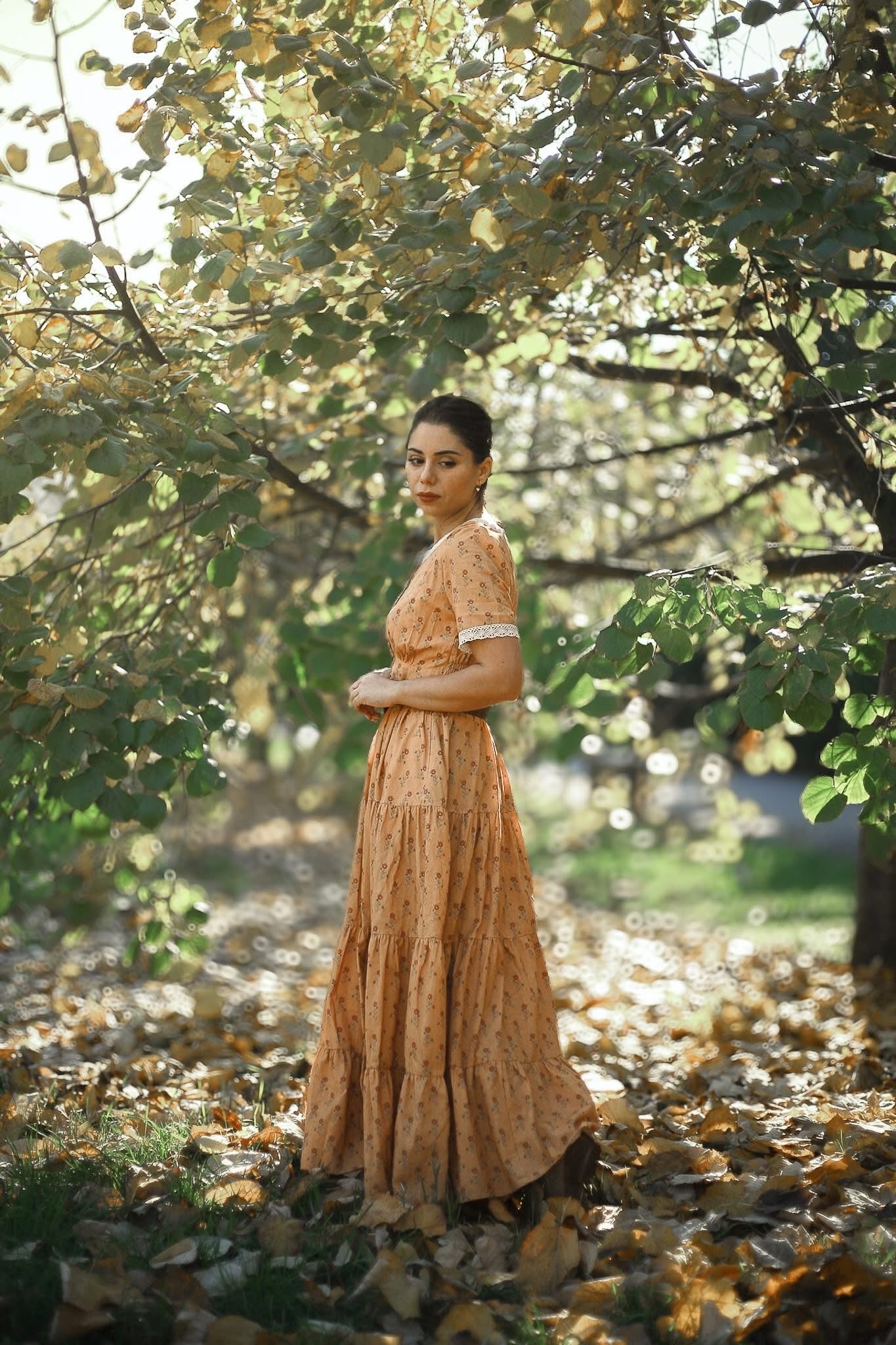 Woman in modest nursing dress trees fallen leaves