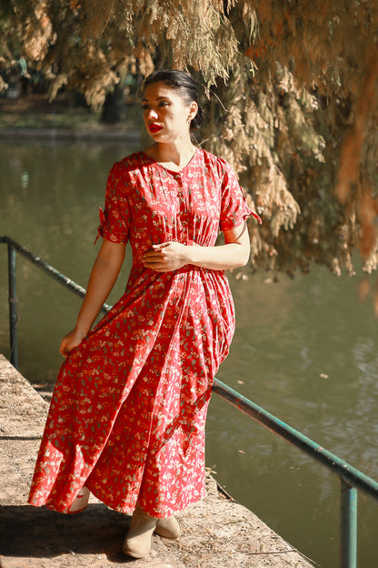 Woman in modest nursing red dress by water