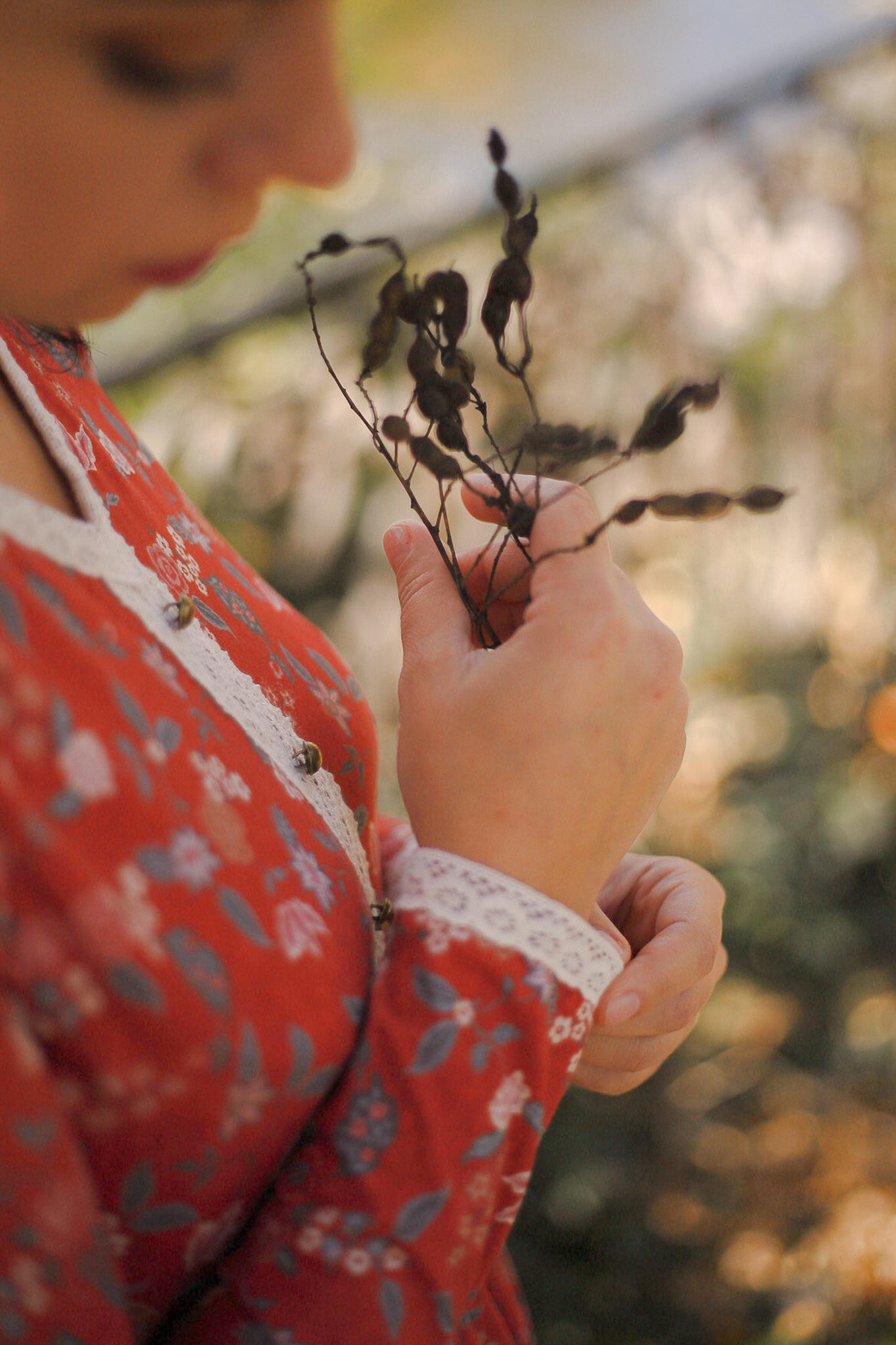 Woman in modest nursing dress holding plant outdoors