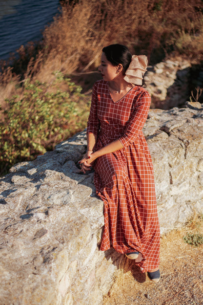 Woman in modest nursing copper windowpane maxi dress 