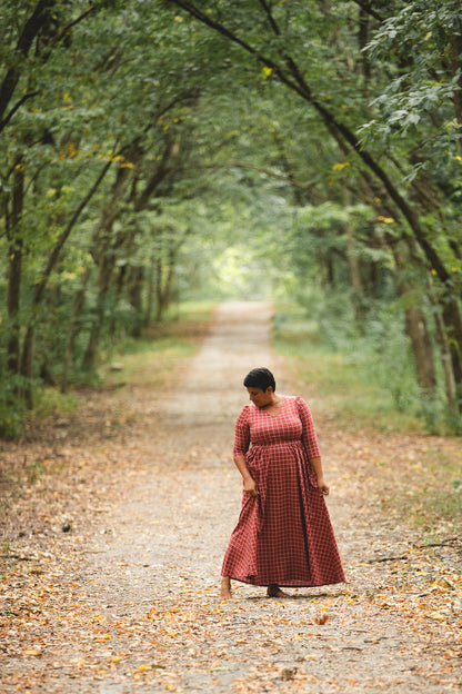 Woman in modest nursing copper windowpane dress forest pathway