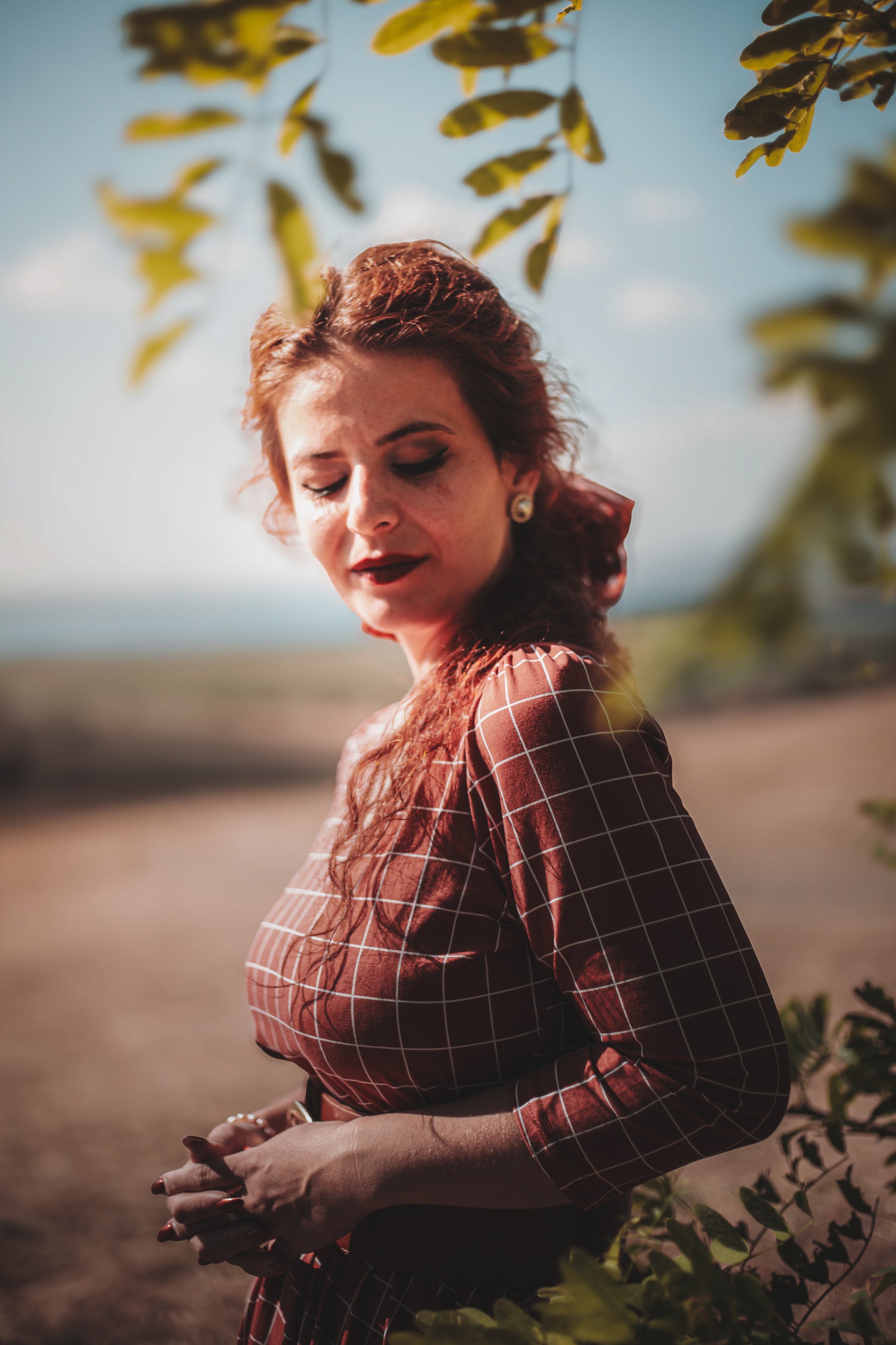 Woman in modest copper windowpane nursing dress outdoors