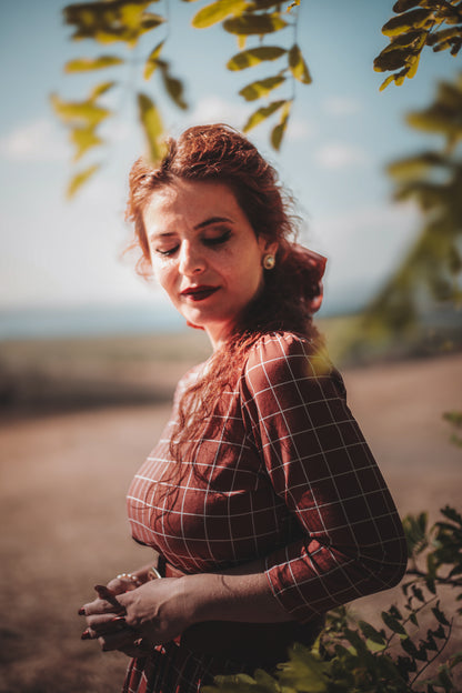 Woman in modest copper windowpane nursing dress outdoors