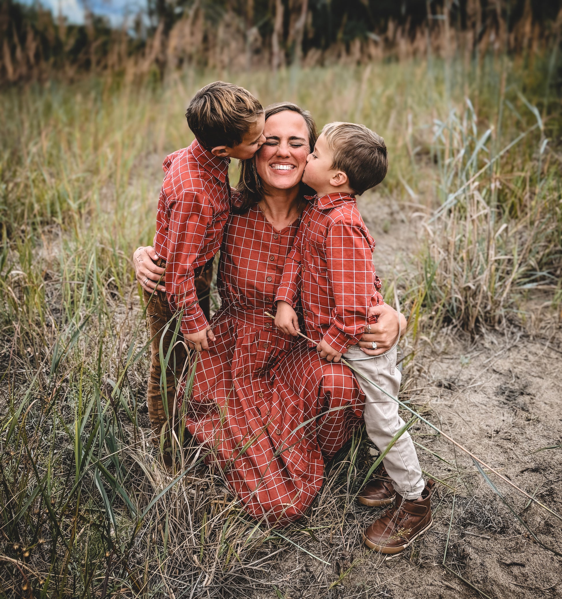 Mother in modest nursing dress with two children outdoors
