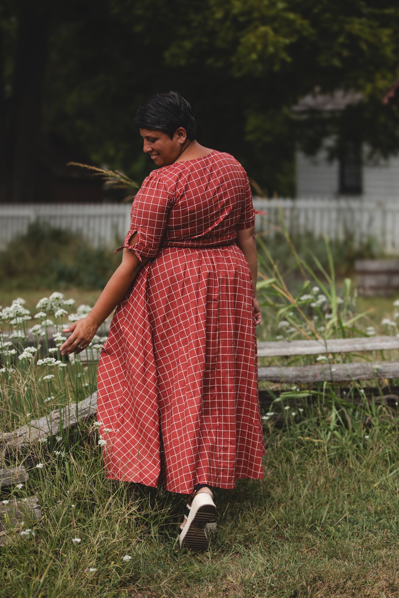 Woman in modest nursing red checkered dress garden
