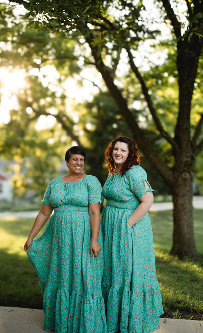 Women in modest nursing teal dresses outdoors