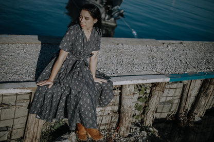 Modest nursing-friendly dark patterned dress by water