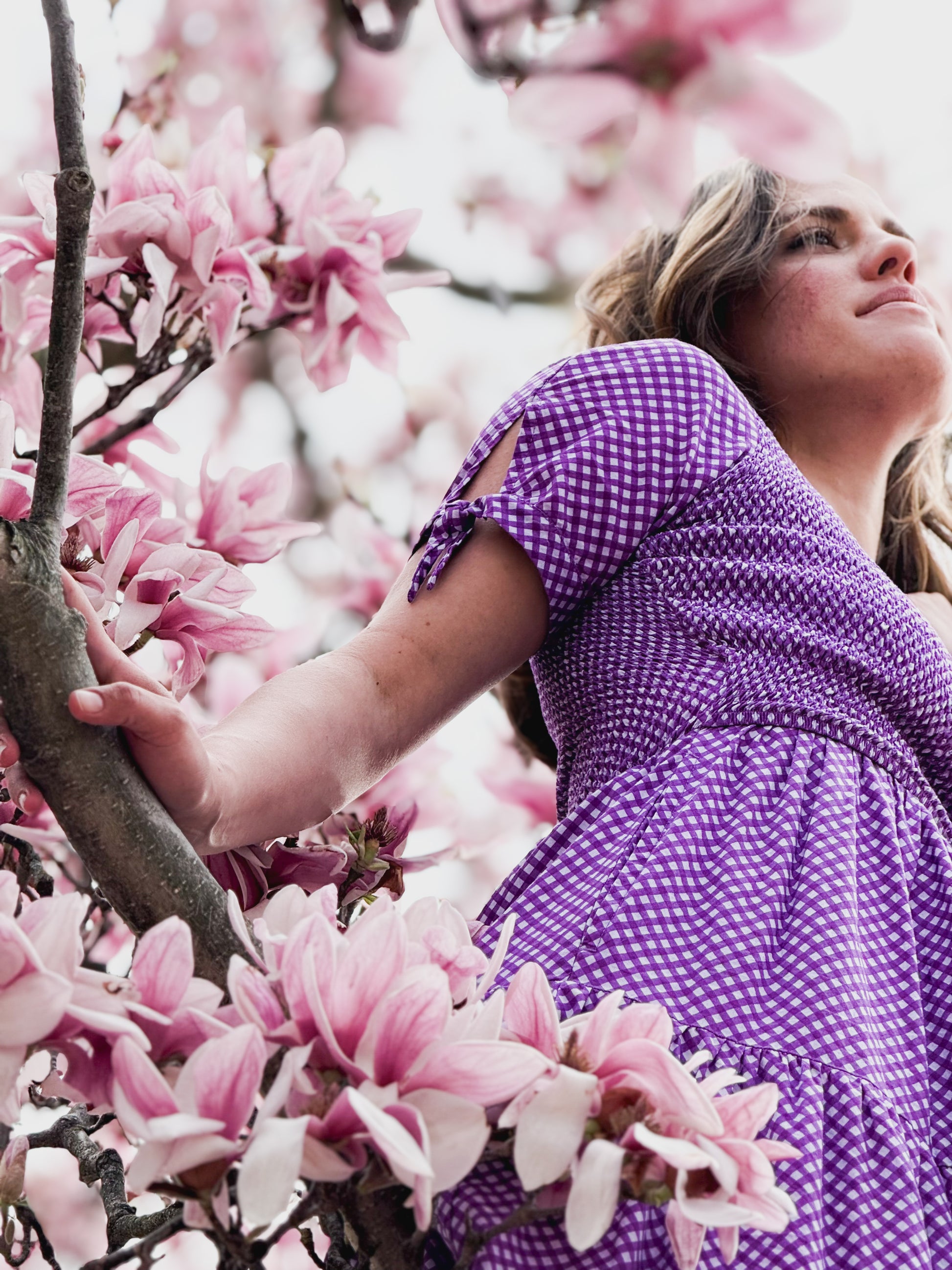 A woman wearing a purple, gingham, five-tiered maxi modest nursing dress