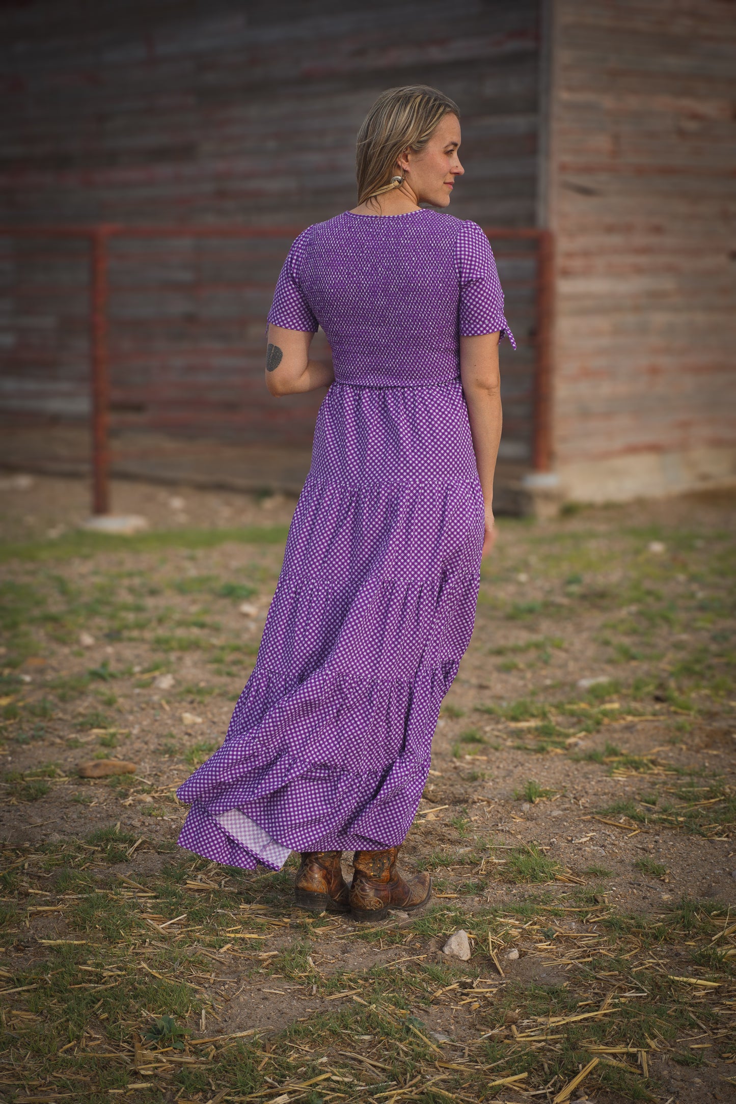 A woman wearing a purple, gingham, five-tiered maxi modest nursing dress