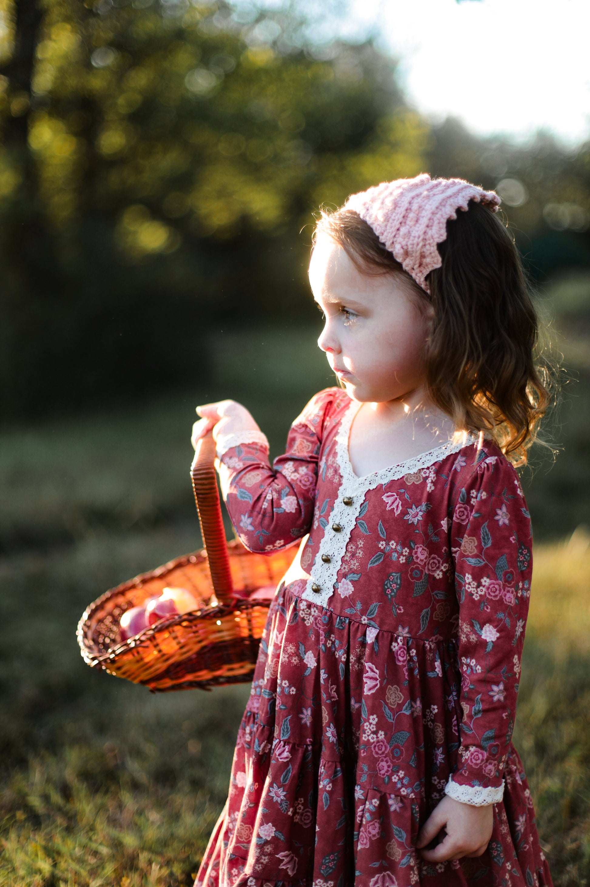 Girl in modest red floral dress with picnic basket