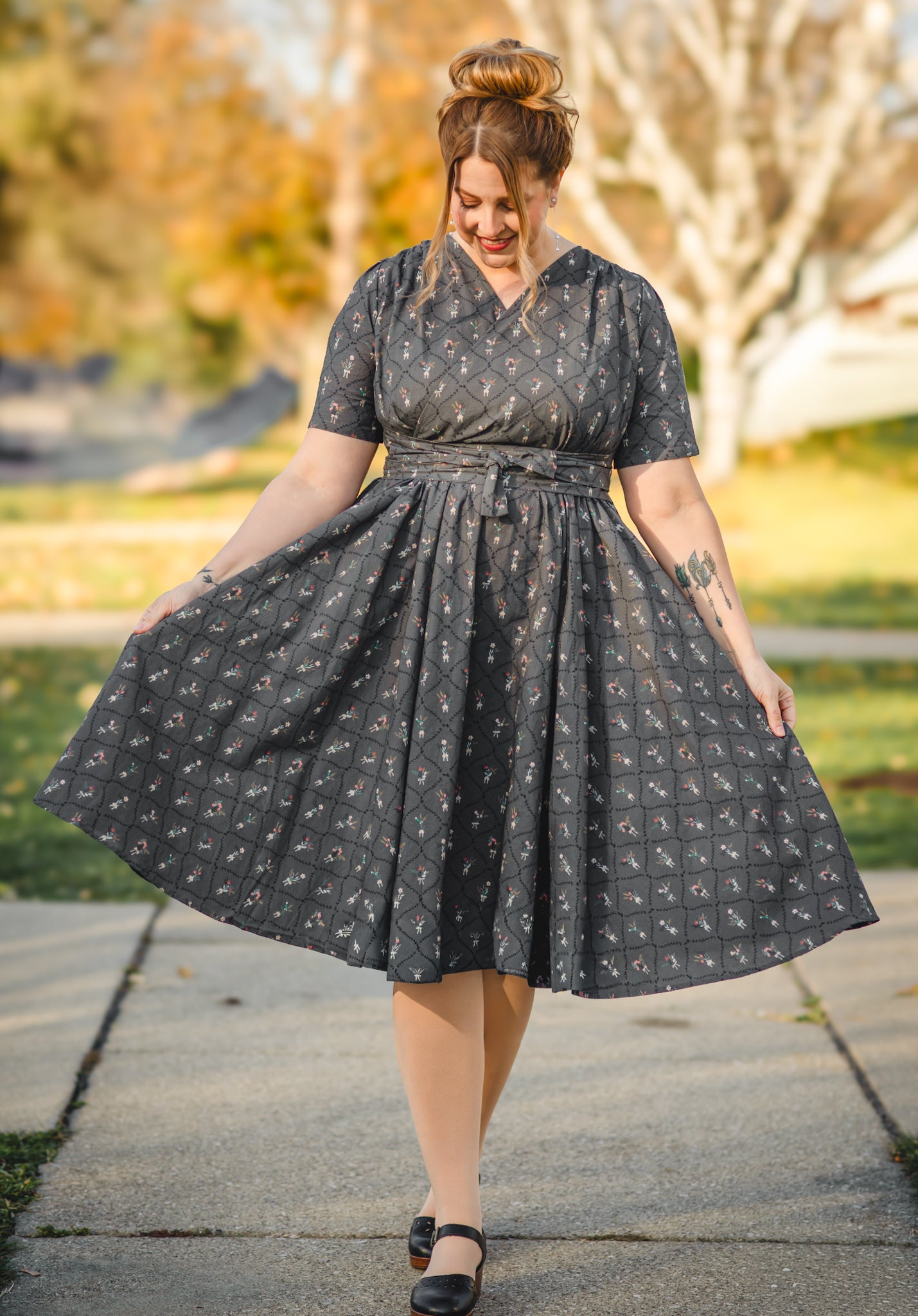 Modest nursing-friendly black patterned dress outdoors