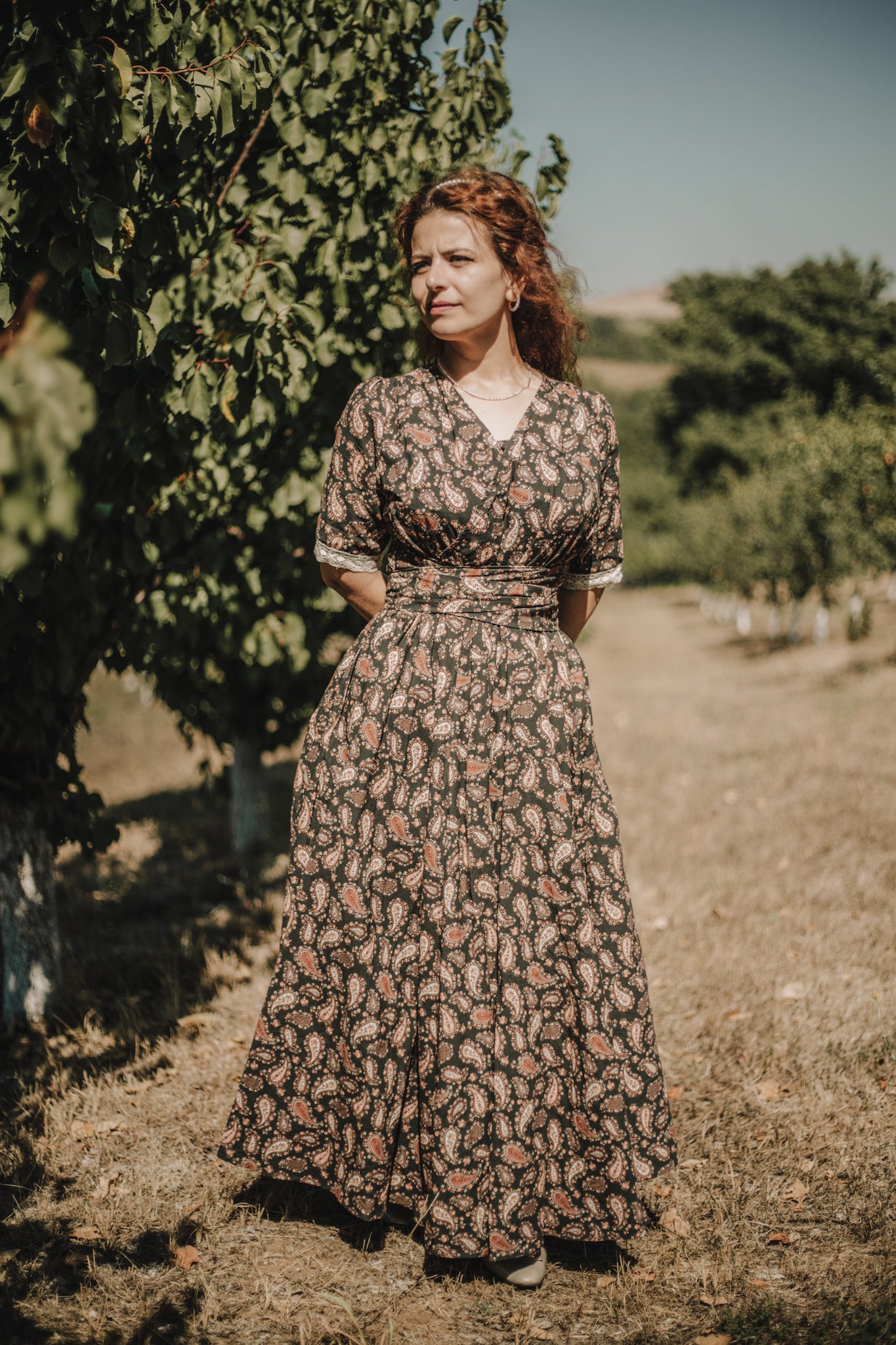 Woman in a floral dress standing in a vineyard