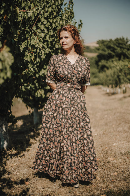 Woman in a floral dress standing in a vineyard