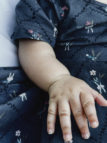 Modest child hand closeup dark floral dress