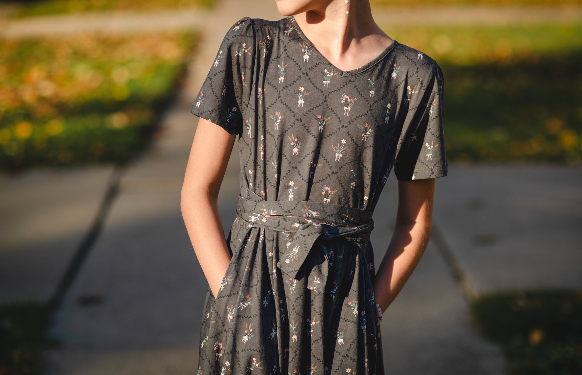 Modest nursing-friendly black floral dress outdoors