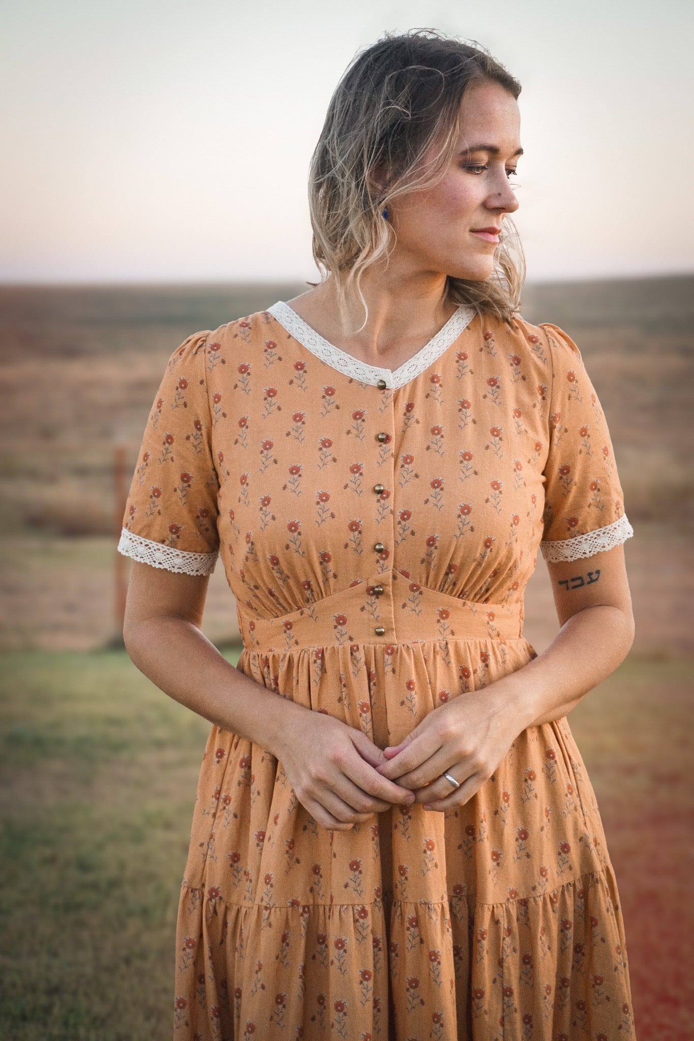 Woman in modest nursing dress standing in field