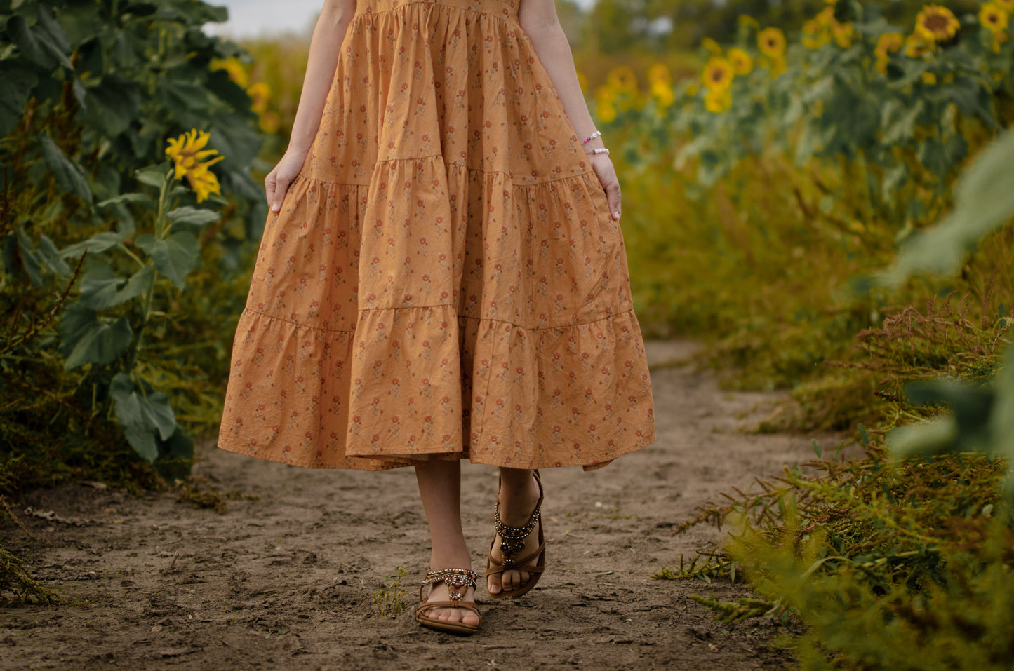 Woman in modest nursing dress in sunflower field
