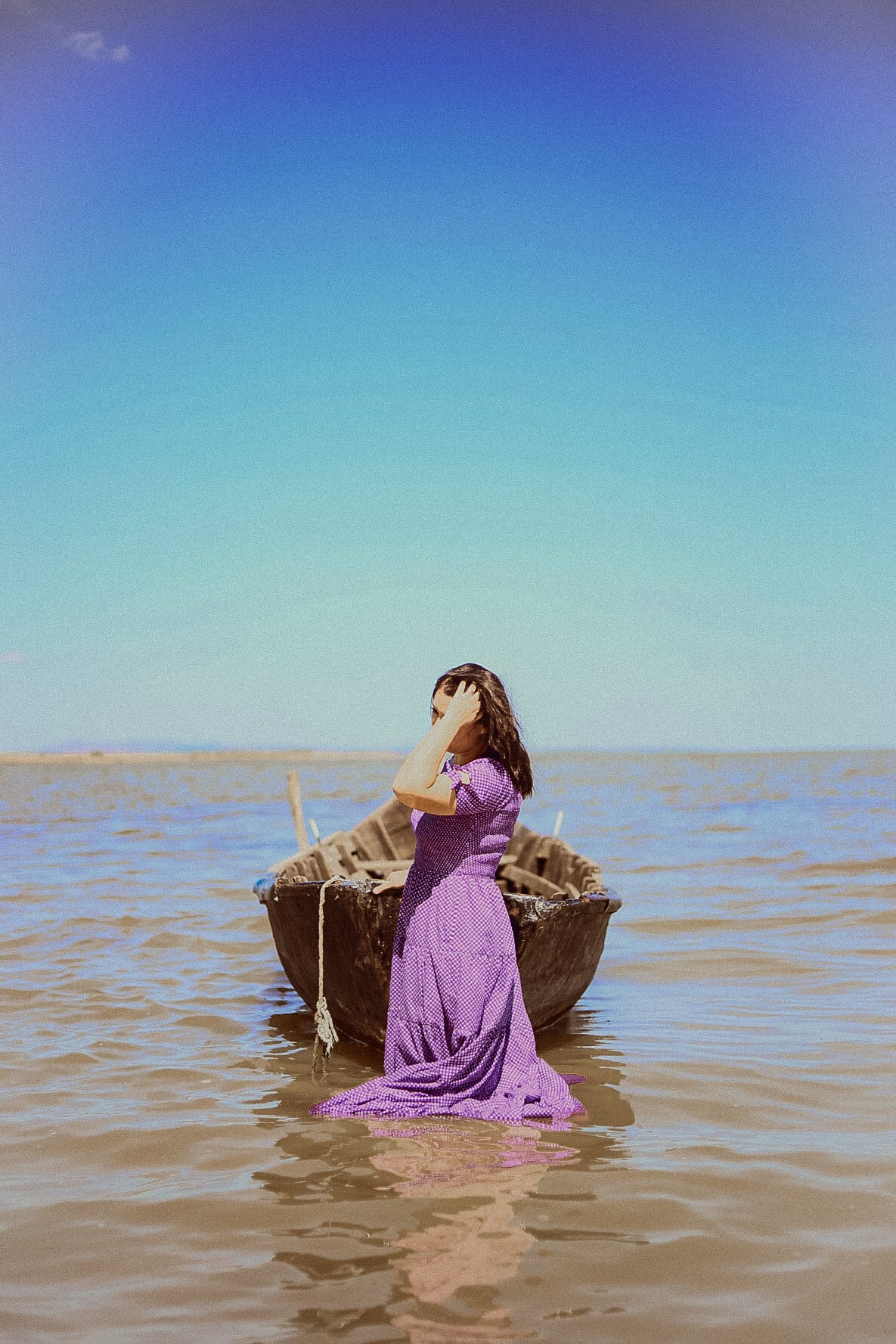 A woman wearing a purple, gingham, five-tiered maxi modest nursing dress